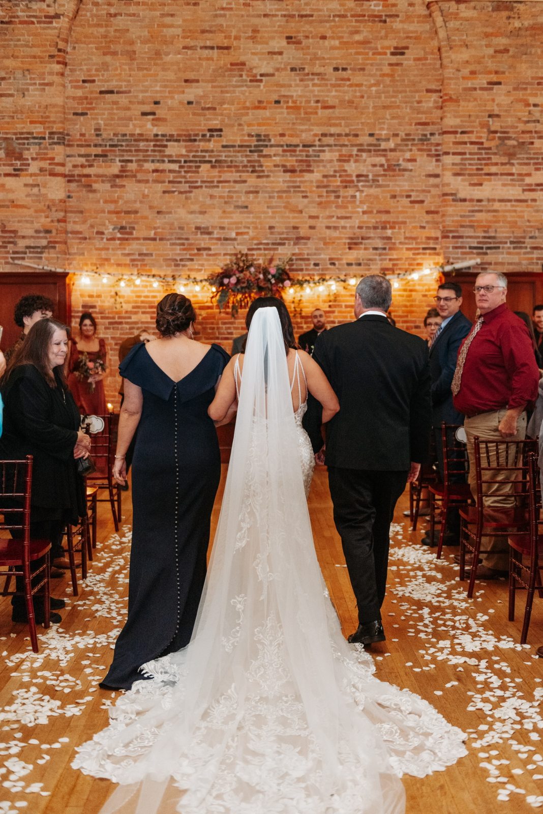 Bride walking down the aisle with her mother and father during wedding ceremony at Springside Inns The Point event venue