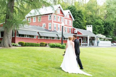Bride and groom kissing in front of Springside Inn. Their wedding venue in the heart of the finger lakes region of New York