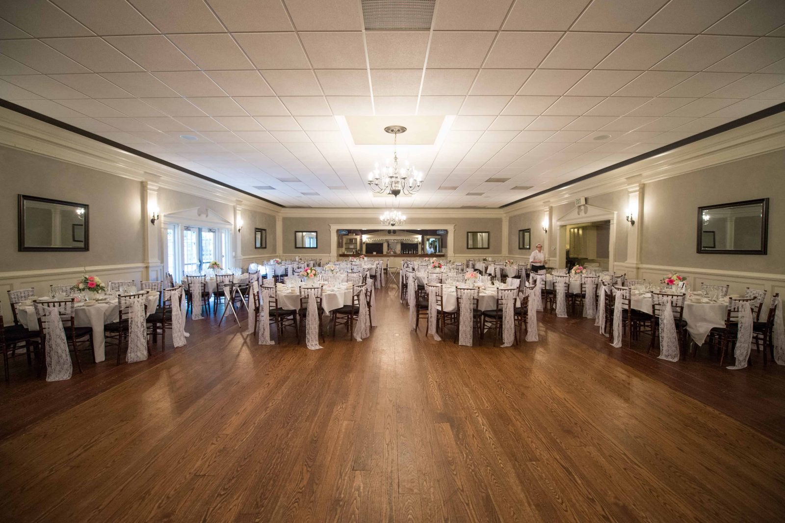 Decorated tables line the ballroom for a wedding reception