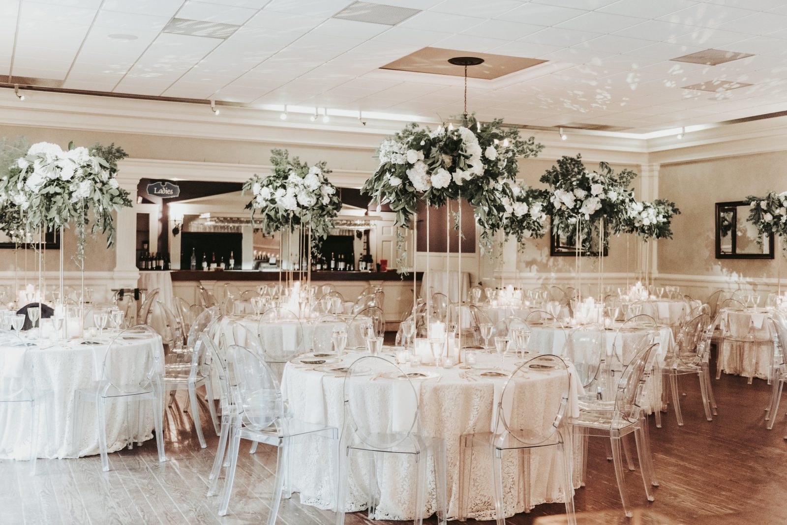 Tall floral arrangements on crisp white tablecloths in the Heritage room